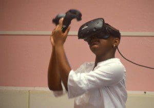 A student practices using the controllers for the HTC Vive