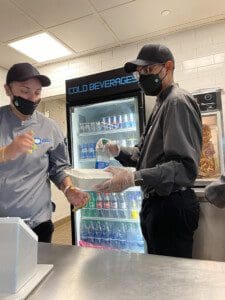 Miguel Mondesir, right, hands an order to a co worker at the Barclays Center concession stand