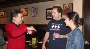 Elvin Flores speaks with guests of his exhibit