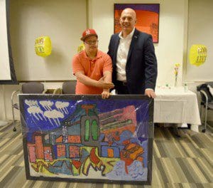 Artist Alex Torres presented Mr. Decker with a painting, thanking him for his support of Adult Day Services programs