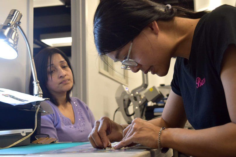 Mei Zhi Zhuang pays close attention as she weeds the vinyl