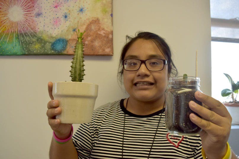 Alexandra Patracio showcases some of the plants the group has been growing