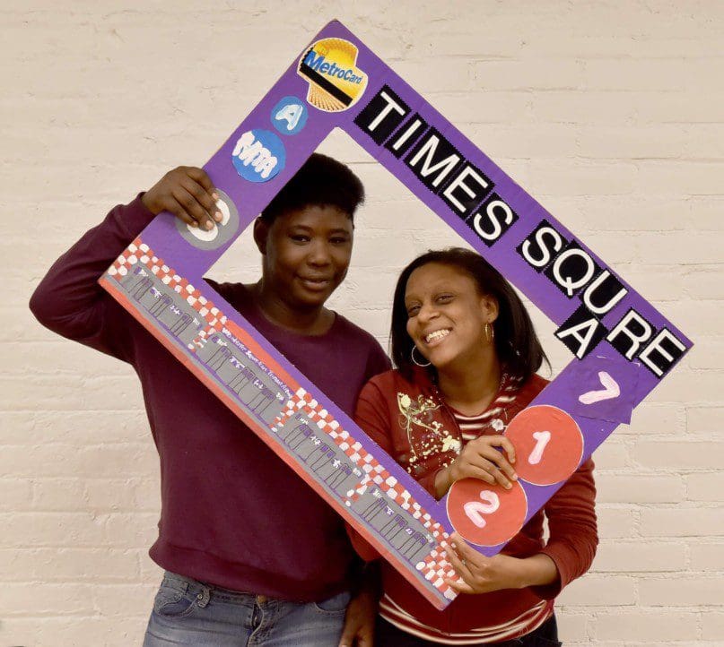 Leeann Washington and Comfort Madison of Church Avenue Day Services pose in the transit themed photo booth