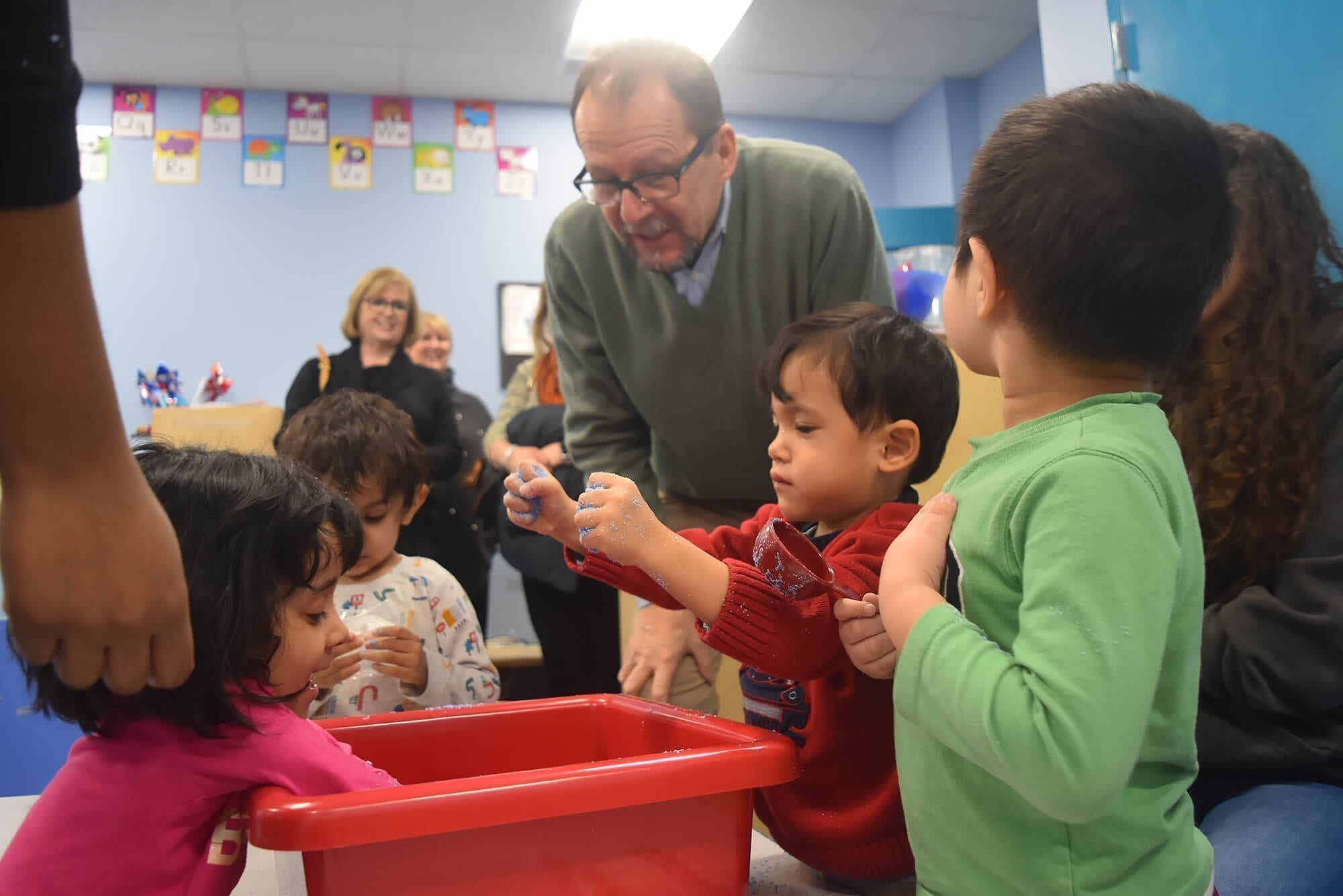 Diana Munson watches as AHRC NYC's CEO, Marco Damiani, engages with the children