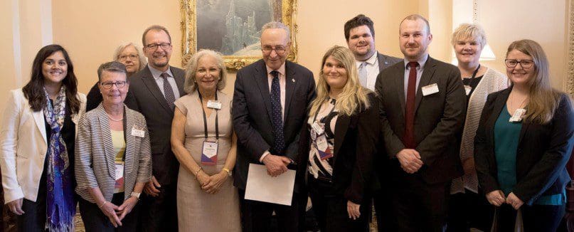 Senator Charles Schumer, center, with representatives from AHRC New York City