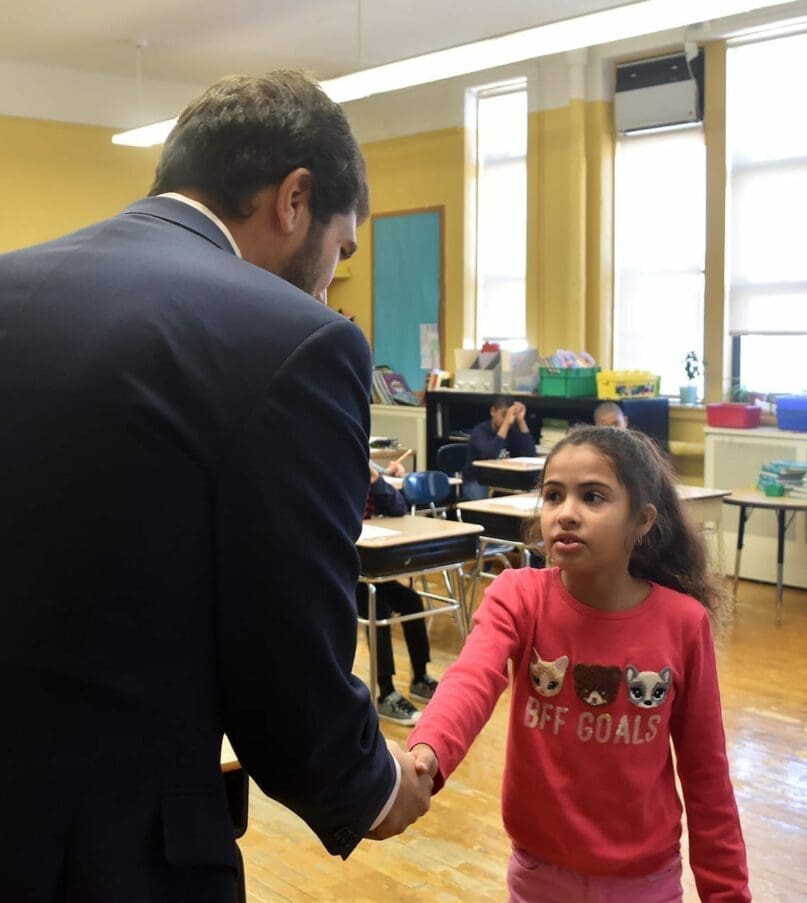 Student, Giana, greets Senator Andrew Gounardes during his visit to Brooklyn Blue Feather