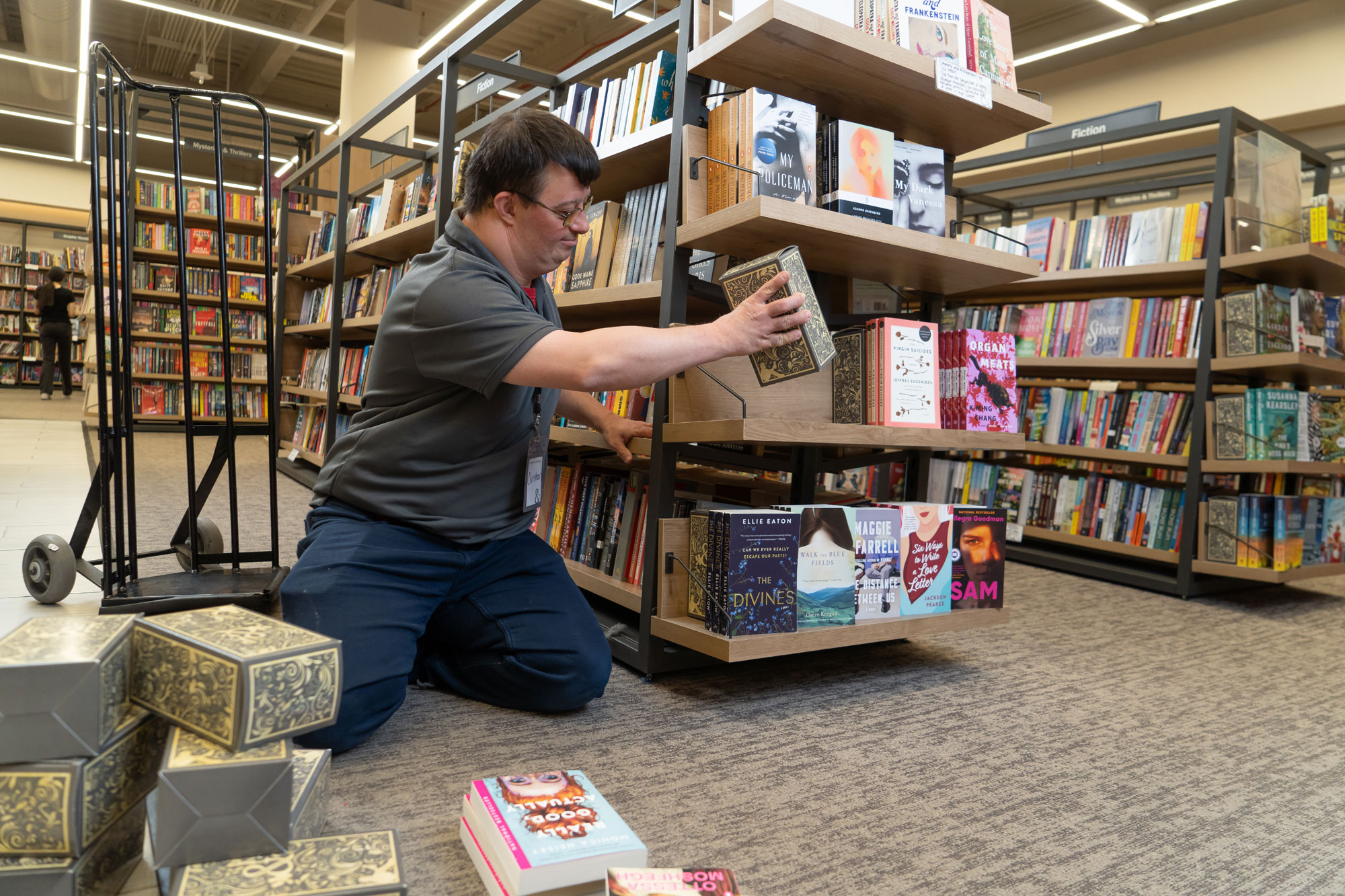 A man stocks shelves in a bookstore.
