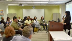Families listen to a speaker from AHRC NYC in the penthouse of AHRC NYC's headquarters, as a part of its Family Education Workshop Series