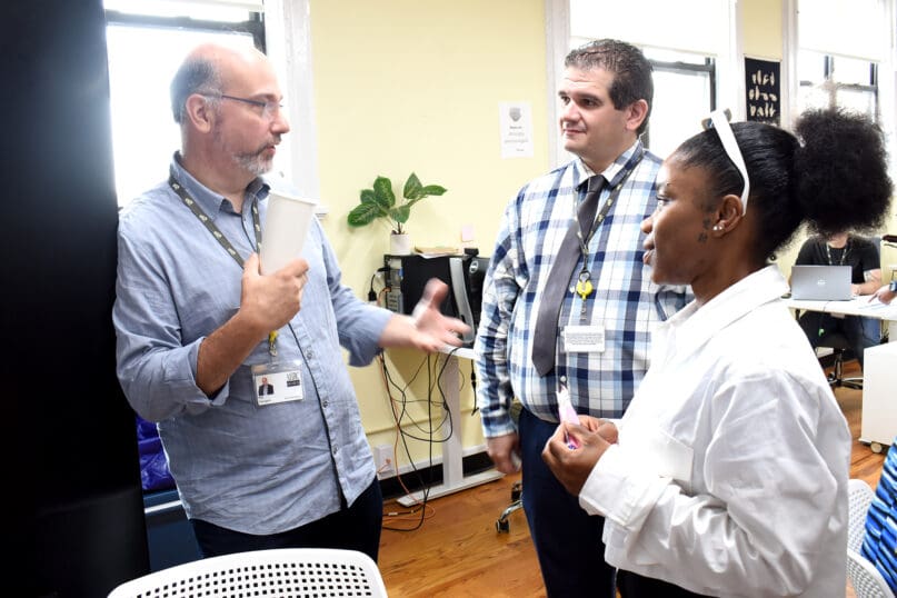 Fatimah Howard, on right, and Edwin Rodriguez Jr. speak with AHRC NYC Board President Ray Ferrigno