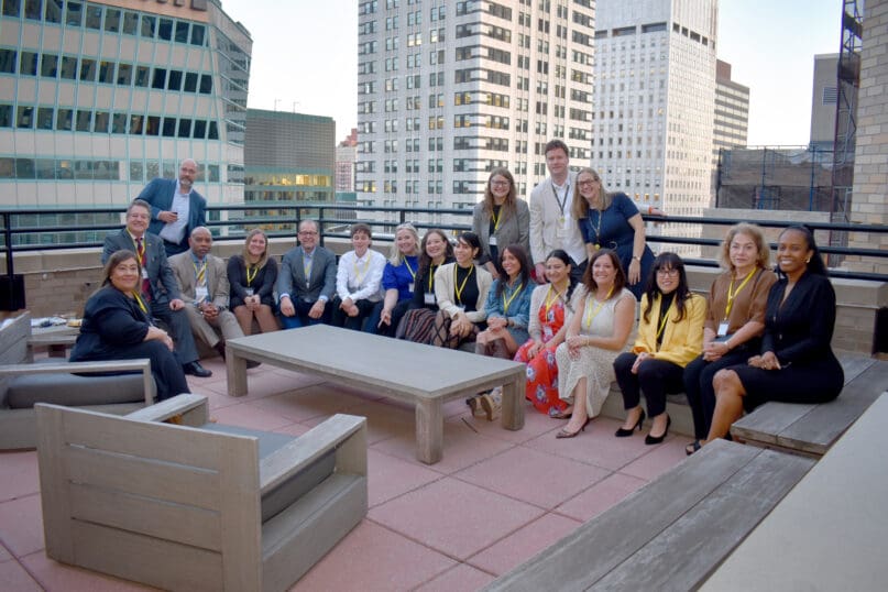 AHRC NYC's Employment & Business Services team gathers for a photo taken on a balcony overlooking the streets of New York City