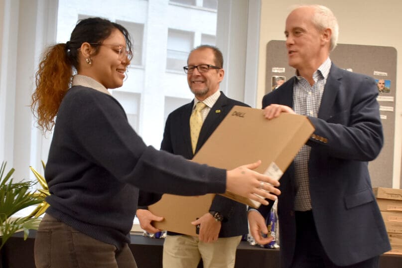 John Emra gives a laptop to an Advance & Earn program participant