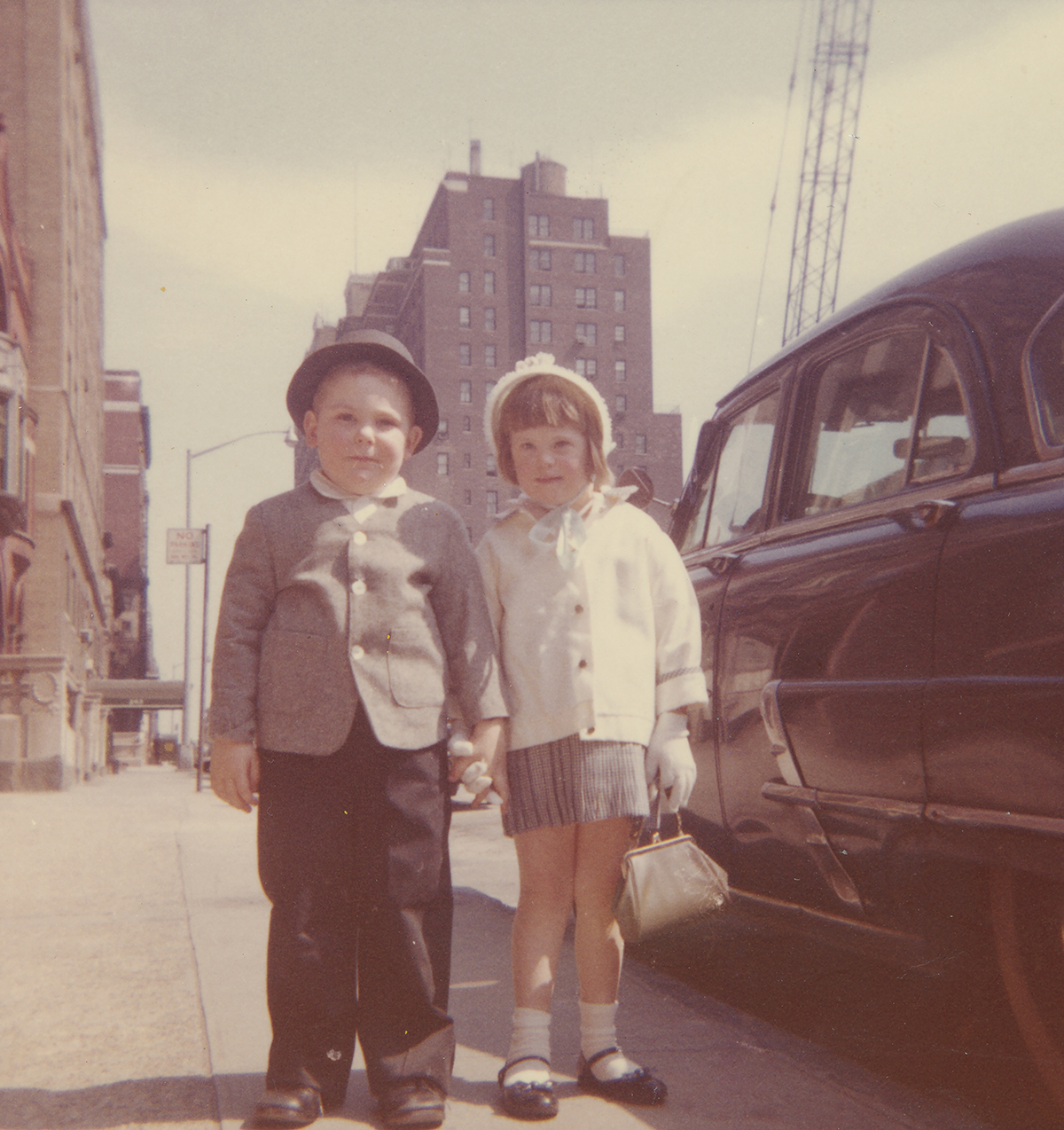Childhood photo of Lisa and Paul holding hands on the street