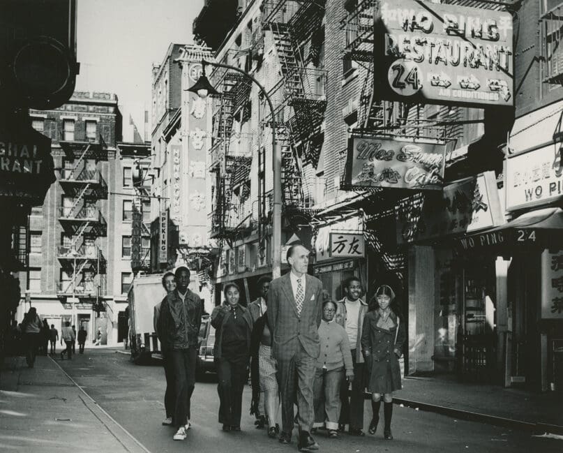 Devino Riondato walks in the community with students, 1950s