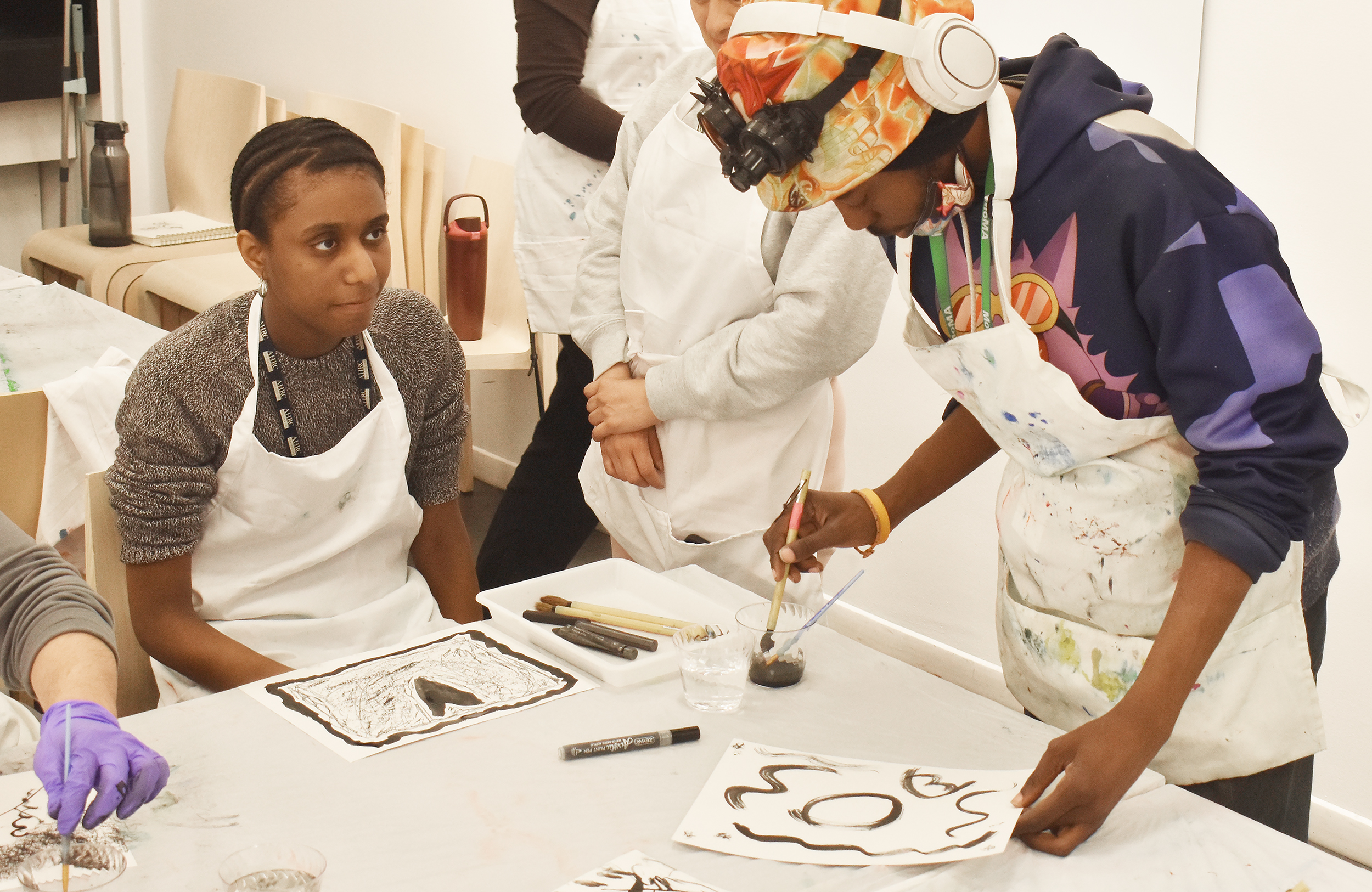 Lineton shows Tamia Hester watches as Lineton demonstrates an abstract painting technique