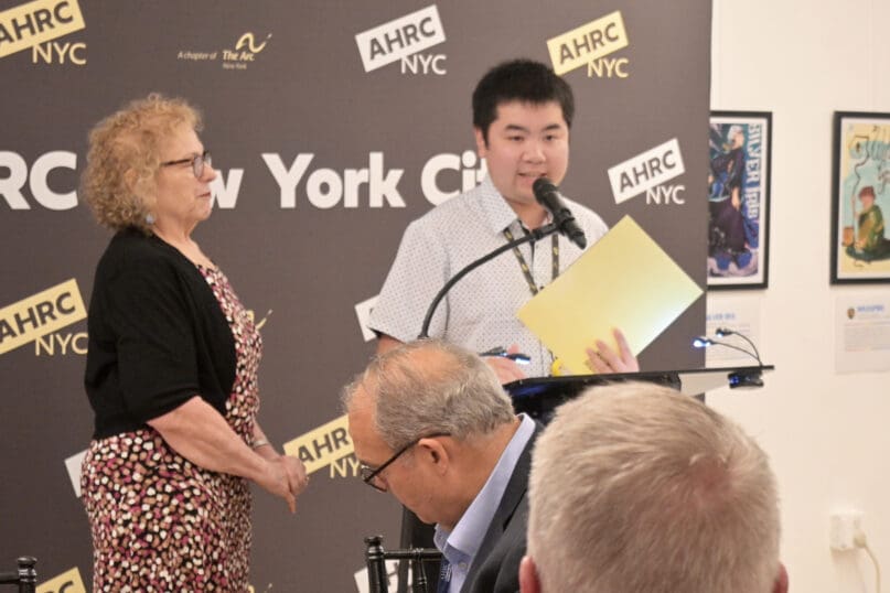 A staff member accepts an award on behalf of Jun Lin from Employment and Business Services